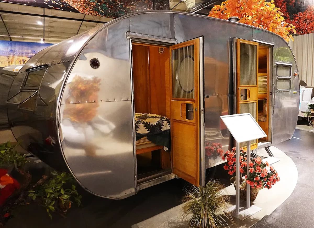 A polished 1954 Yellowstone travel trailer with its doors open