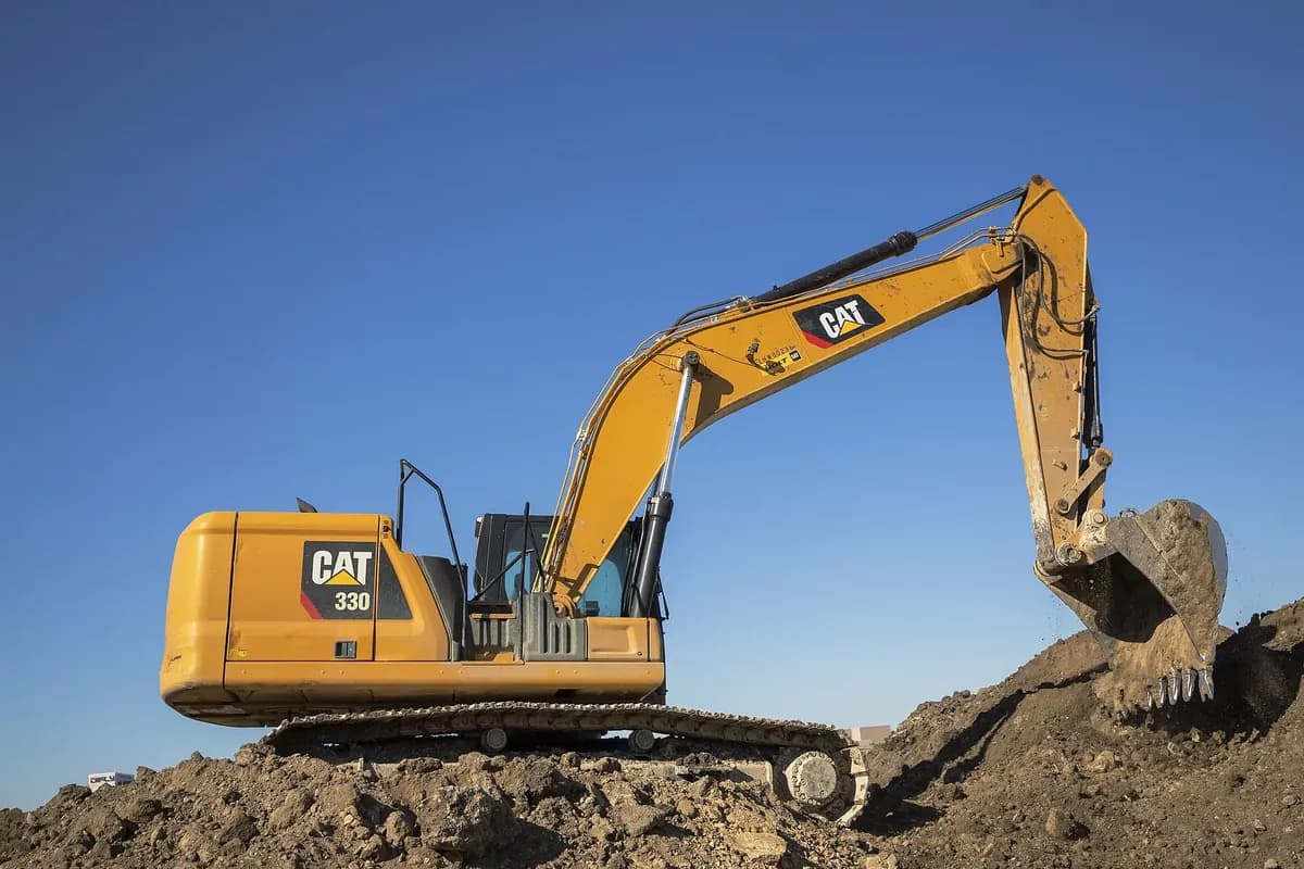 A Caterpillar 330 excavator working a pile of earth