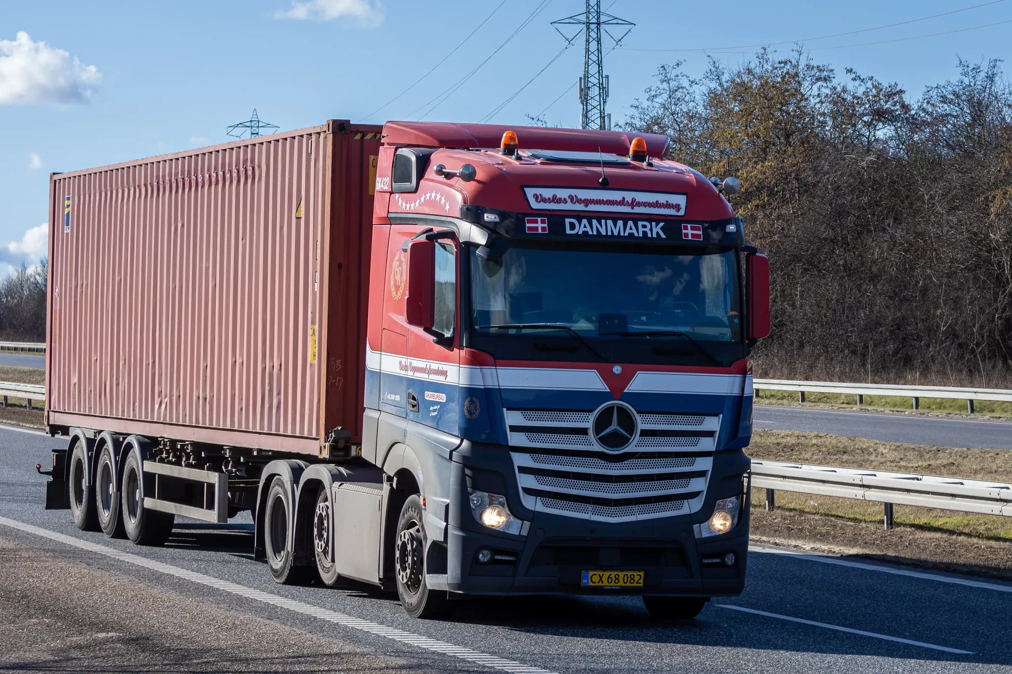A container semi-trailer truck at speed on a motorway