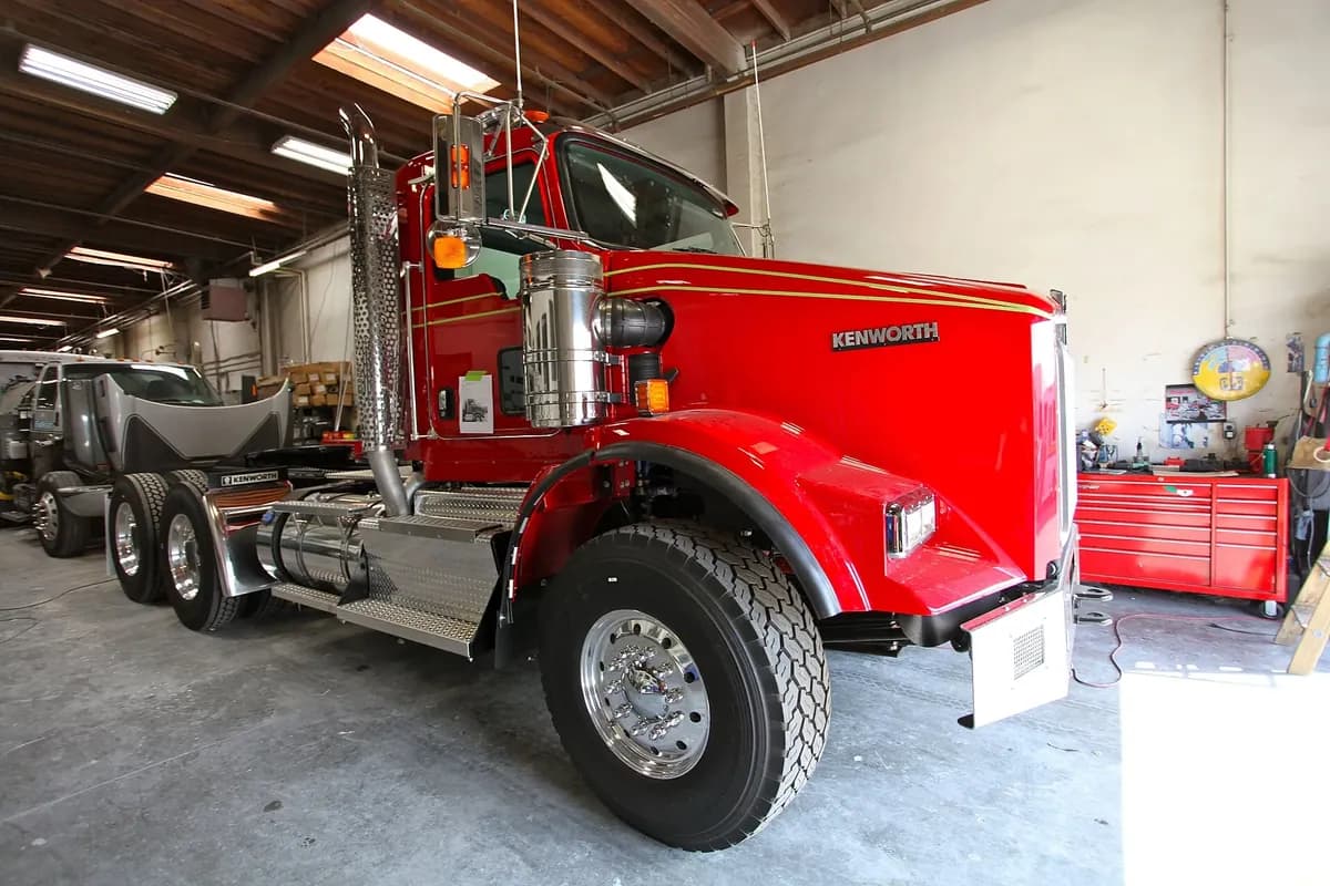 A heavy truck up on the floor of a repair shop